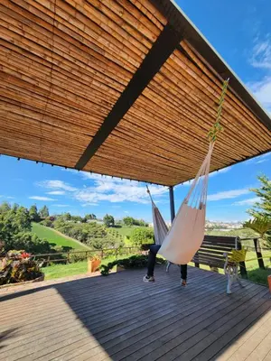 a woman sitting on a deck with two hammocks at San José de las bromelias in Marinilla