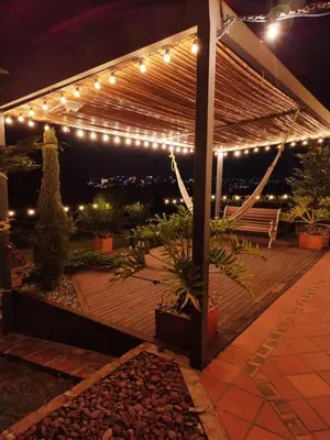 a pergola lit up at night with lights at San José de las bromelias in Marinilla
