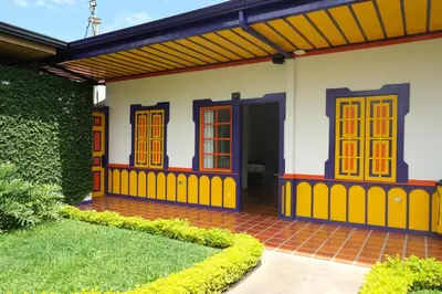 a house with a yellow and blue paint on it at Atardeceres del Cafe in Manizales
