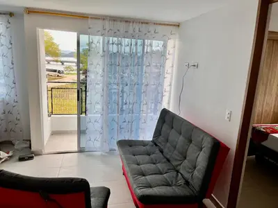 a living room with a couch and a sliding glass door at Travelu Guatape Apartamento in Guatapé