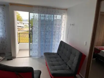 a living room with a couch and a sliding glass door at Travelu Guatape Apartamento in Guatapé