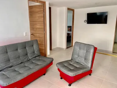 two chairs and a couch in a living room at Travelu Guatape Apartamento in Guatapé