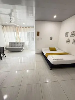 a white bedroom with a bed and a couch at TORRES DEL MESÓN LUXURY APARTA HOTEL Doradal in Doradal