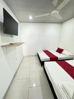 a room with two beds and a flat screen tv at TORRES DEL MESÓN LUXURY APARTA HOTEL Doradal in Doradal