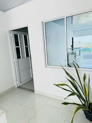 a white room with a window and a potted plant at TORRES DEL MESÓN LUXURY APARTA HOTEL Doradal in Doradal