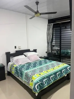 a bedroom with a bed with a ceiling fan at Hotel RIO Y SOL DORADO in La Dorada