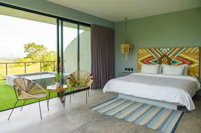 a bedroom with a large bed and a balcony at Hotel Piedra Mulata - Adults Only in Doradal