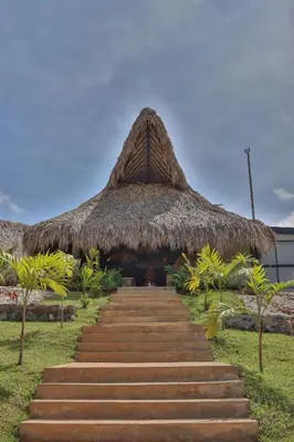 a staircase leading up to a thatched building with a grass roof at Hotel Piedra Mulata - Adults Only in Doradal