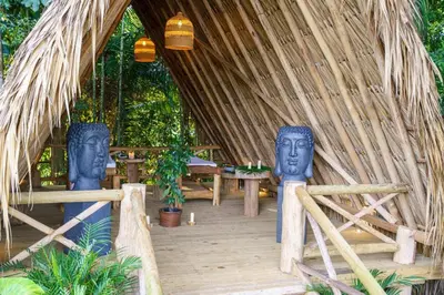 two statues of heads are in a thatched building at Hotel Piedra Mulata - Adults Only in Doradal