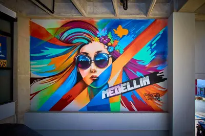 a large painting of a woman with sunglasses on a wall at Mangata Living by Bernalo Hotels in Medellín