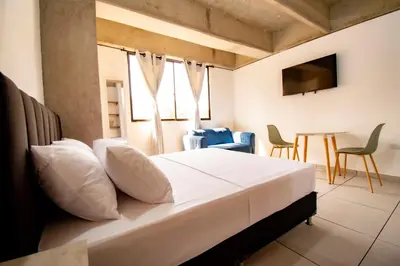 a bedroom with a bed and a table and chairs at Mangata Living by Bernalo Hotels in Medellín