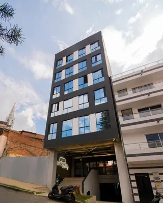 a tall black building with a motorcycle parked in front of it at Mangata Living by Bernalo Hotels in Medellín