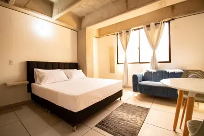 a bedroom with a bed and a couch and a table at Mangata Living by Bernalo Hotels in Medellín
