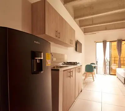 a kitchen with a black refrigerator in a room at Mangata Living by Bernalo Hotels in Medellín