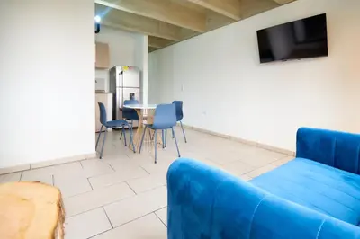 a living room with a blue couch and a table at Mangata Living by Bernalo Hotels in Medellín
