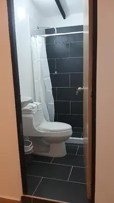 a bathroom with a toilet and blue tiles at PRIMAVERA LIVING in Medellín