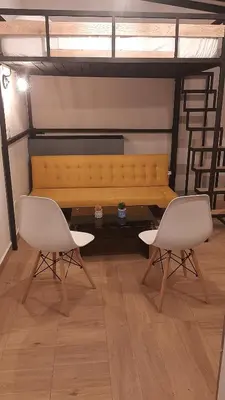 a yellow couch in a room with two chairs at PRIMAVERA LIVING in Medellín
