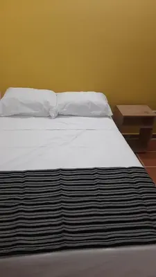 a bed with a black and white blanket on it at PRIMAVERA LIVING in Medellín