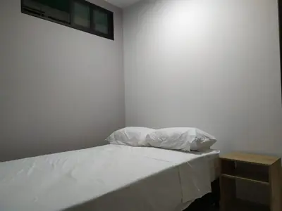 a bedroom with a bed with white sheets and a nightstand at PRIMAVERA LIVING in Medellín