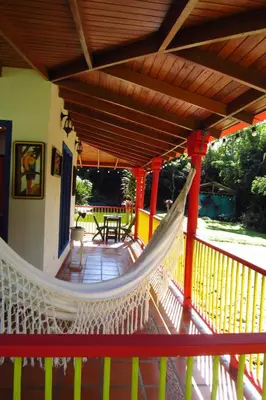 a porch with a hammock on a house at CASA DE CAMPO VILLA OLI!! - Un paraiso natural en la ciudad in Villamaría