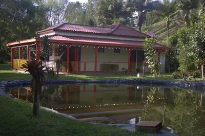 a house with a pond in front of it at CASA DE CAMPO VILLA OLI!! - Un paraiso natural en la ciudad in Villamaría