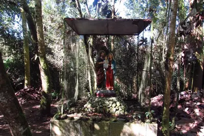 two people standing in a shrine in a forest at CASA DE CAMPO VILLA OLI!! - Un paraiso natural en la ciudad in Villamaría