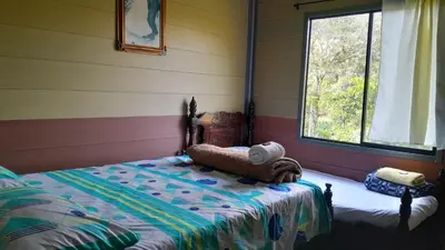 a bedroom with a bed in a room with a window at Cabaña La Guitarra in Betania