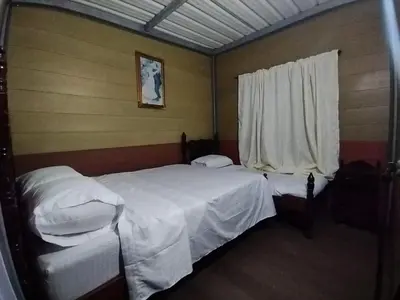 a bedroom with two beds and a window at Cabaña La Guitarra in Betania
