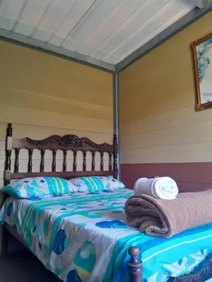 a bed with towels on it in a room at Cabaña La Guitarra in Betania