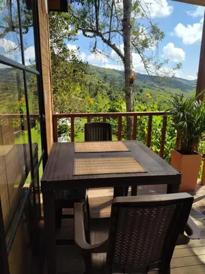 a table and chairs on a balcony with a view at Cabaña Momotus I in Concepción