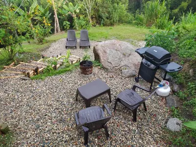a group of chairs and tables and a grill at Cabaña Momotus I in Concepción