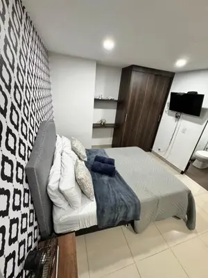 a bedroom with a bed and a couch and a tv at 1208 Beautiful apartment, exclusive area in the poblado in Medellín