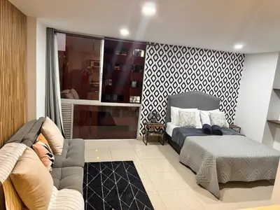 a bedroom with a bed and a couch at 1208 Beautiful apartment, exclusive area in the poblado in Medellín