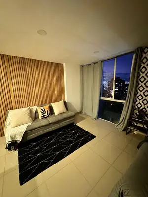 a living room with a couch and a large window at 1208 Beautiful apartment, exclusive area in the poblado in Medellín