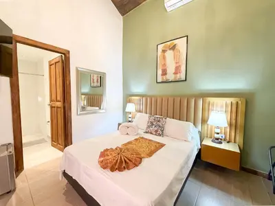 a bedroom with a bed with white sheets and pillows at Hotel Recuerdos de mi Tierra El Poblado Provenza in Medellín