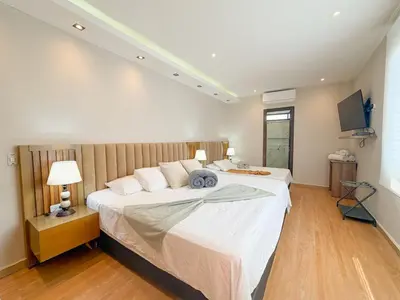 a bedroom with a large bed and a television at Hotel Recuerdos de mi Tierra El Poblado Provenza in Medellín