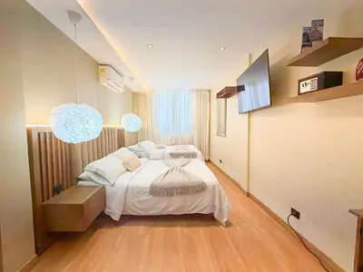 a bedroom with a large bed with white sheets at Hotel Recuerdos de mi Tierra El Poblado Provenza in Medellín