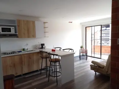 a kitchen with a counter and stools in a room at Hermoso apartamento Medellín in Medellín