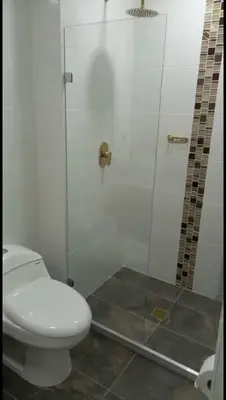 a bathroom with a toilet and a glass shower at Hermoso apartamento Medellín in Medellín