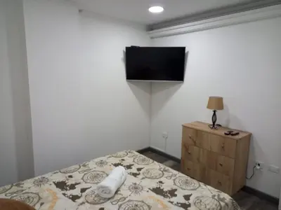 a bedroom with a bed and a television on the wall at Hermoso apartamento Medellín in Medellín
