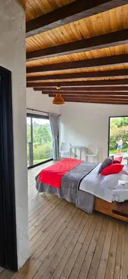 a bedroom with a large bed and a wooden floor at La escondida in Guarne