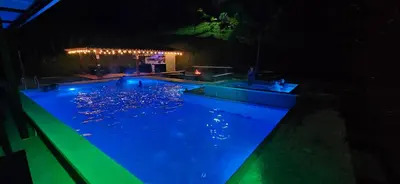 a swimming pool at night with lights in it at La escondida in Guarne