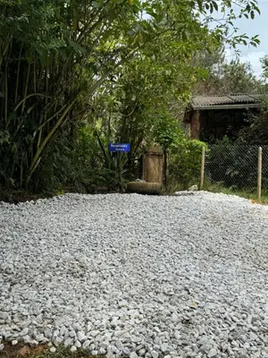 a gravel driveway with a blue sign on it at Beehouse Arví Cabaña in Guarne