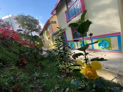 a building with a yellow flower in front of it at Aparta Hotel Jardines de Guatape By Hope in Guatapé
