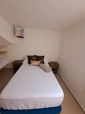 a bedroom with a white bed with two night stands at Aparta Hotel Jardines de Guatape By Hope in Guatapé