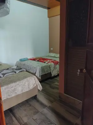 two beds in a room with a door open at ApartaHotel El Balcón del Tolima in Falan
