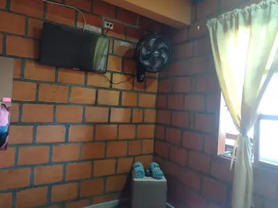 a brick wall with a tv on a brick wall at ApartaHotel El Balcón del Tolima in Falan