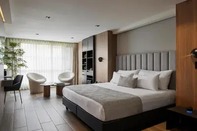 a bedroom with a large bed and a table and chairs at Hotel Selis in Medellín