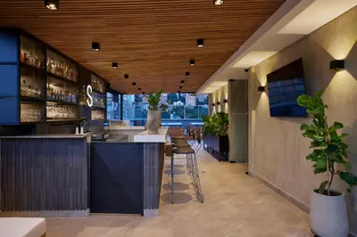 a bar in a restaurant with tables and chairs at Hotel Selis in Medellín