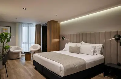 a bedroom with a large white bed and a chair at Hotel Selis in Medellín